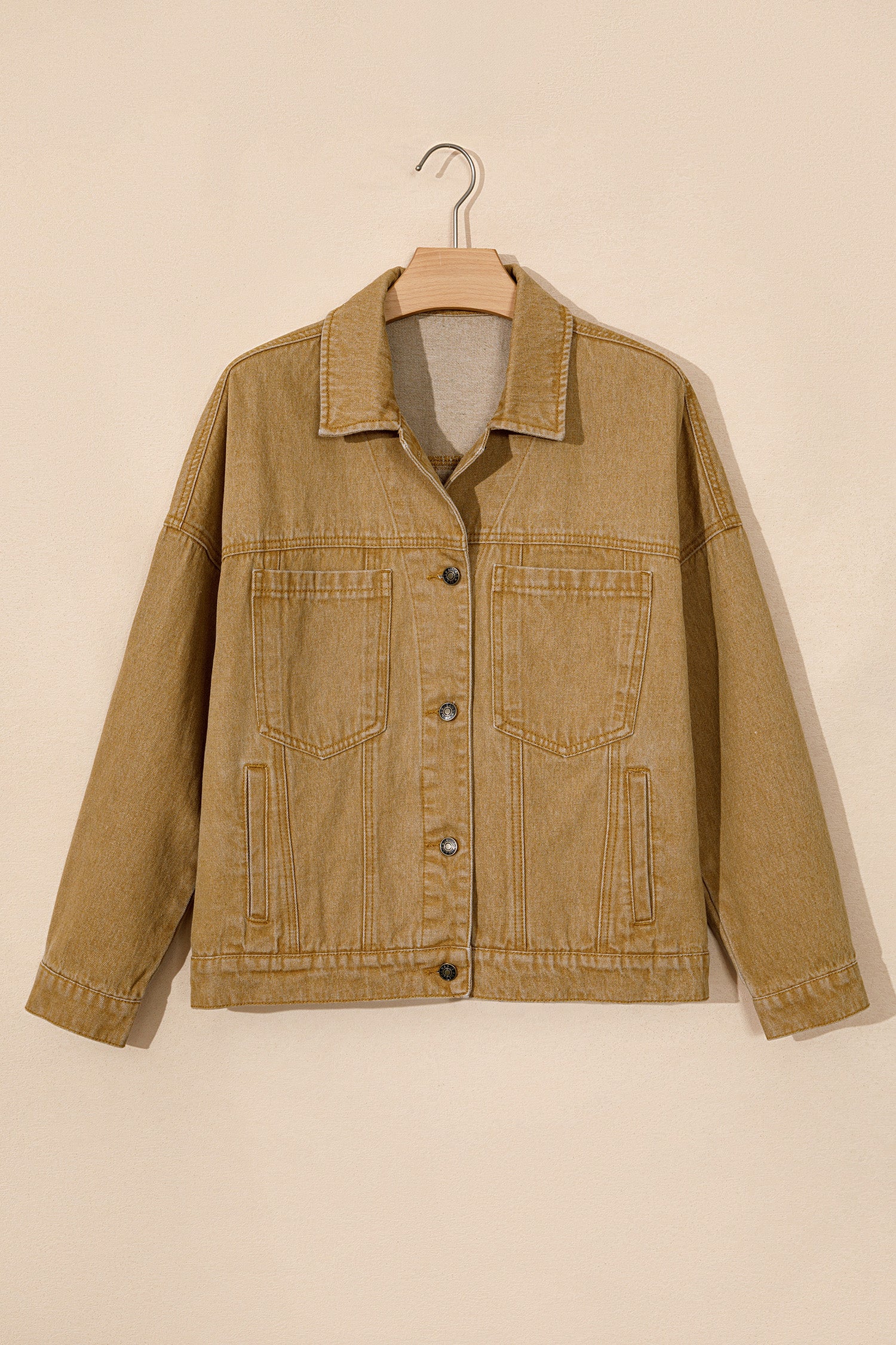 Tan corduroy utility jacket with pointed collar, button front, and two flap pockets on hanger.