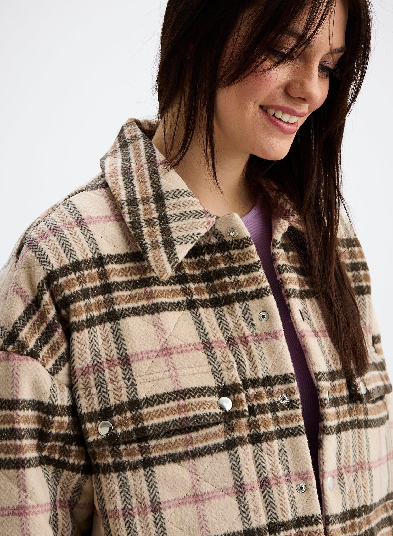 Woman wearing a plaid coat on a white background