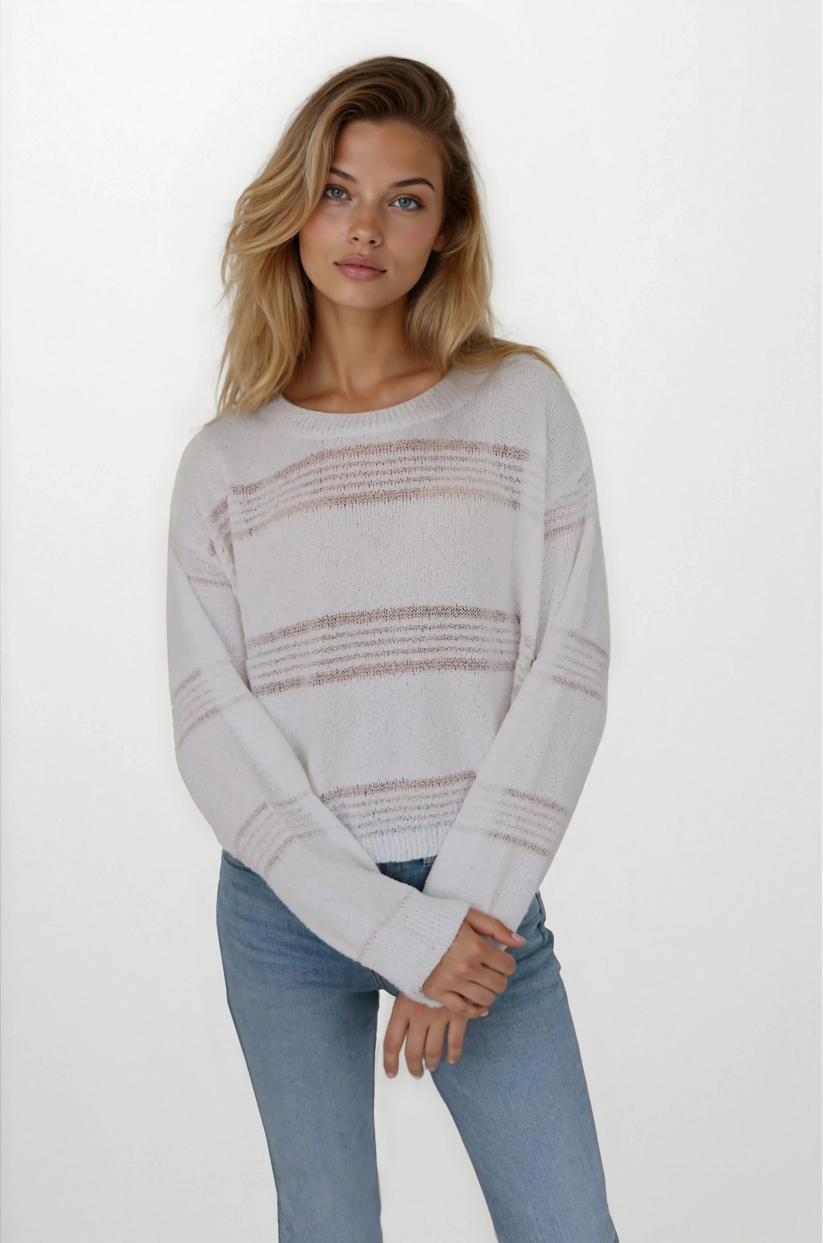 Woman wearing a light gray sweater with horizontal stripes and blue jeans on a white background