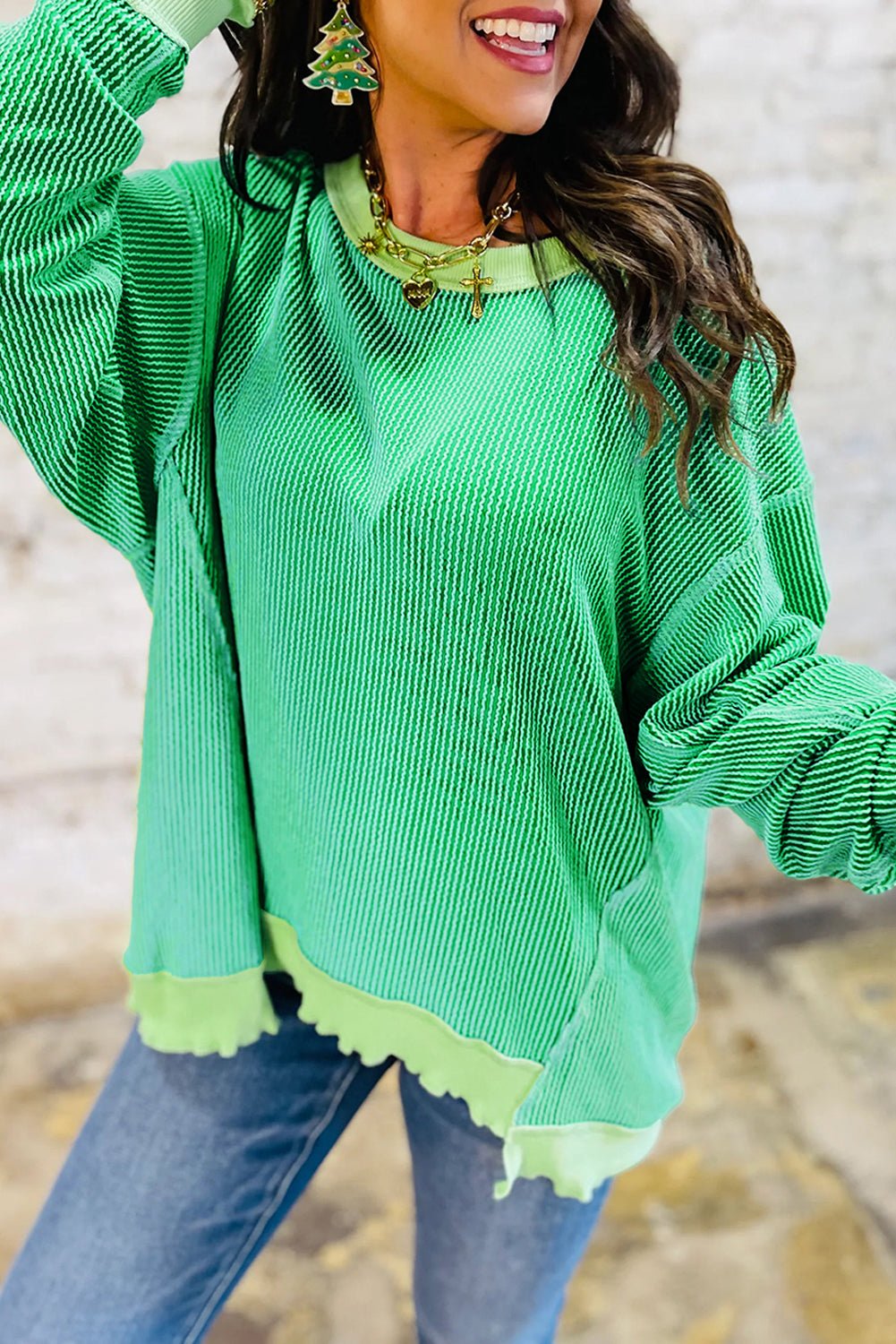 Person wearing a green sweater with a blurred background