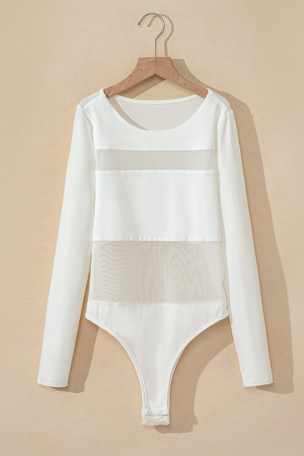 White bodysuit with sheer panels on a beige background