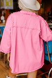 Person wearing a pink jacket with pearl embellishments in an indoor setting