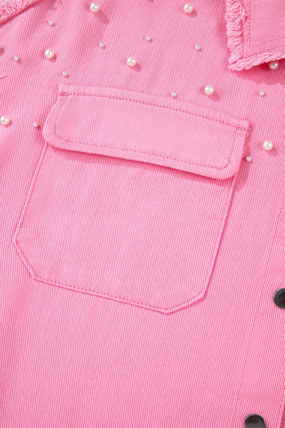 Close-up of a pink pocket with decorative beads on a garment.