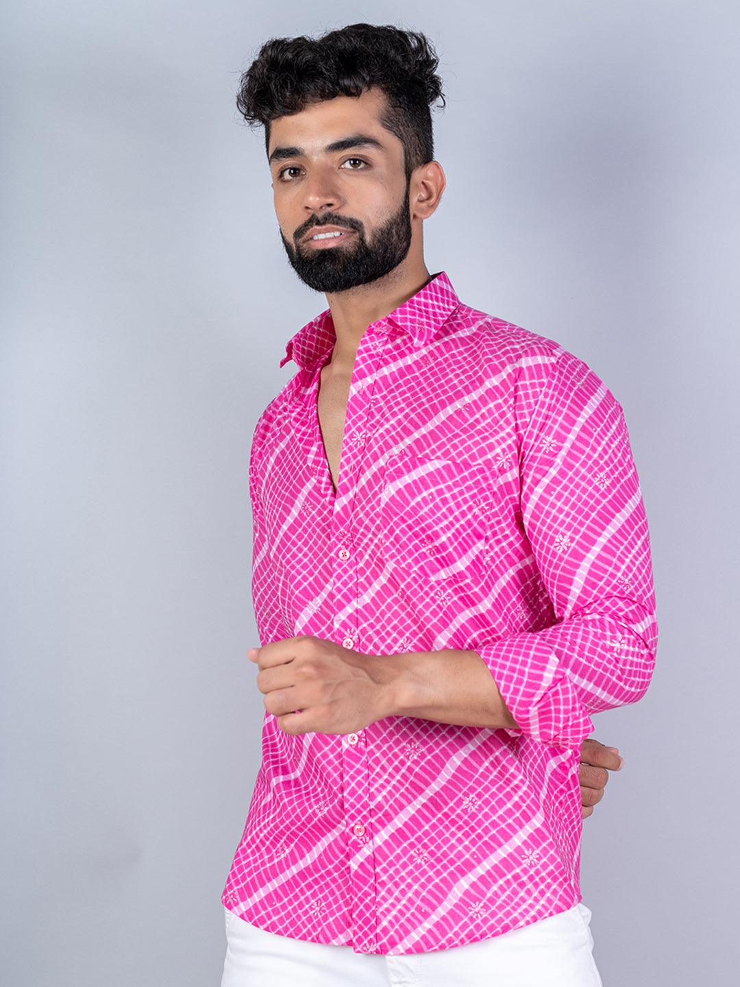 Man wearing a bright pink patterned shirt against a gray background