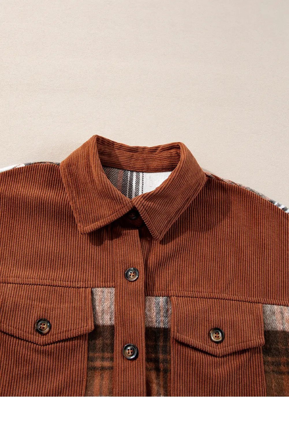 Brown corduroy shirt with plaid lining on a beige background