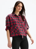 Woman wearing a red and black plaid shirt on a white background