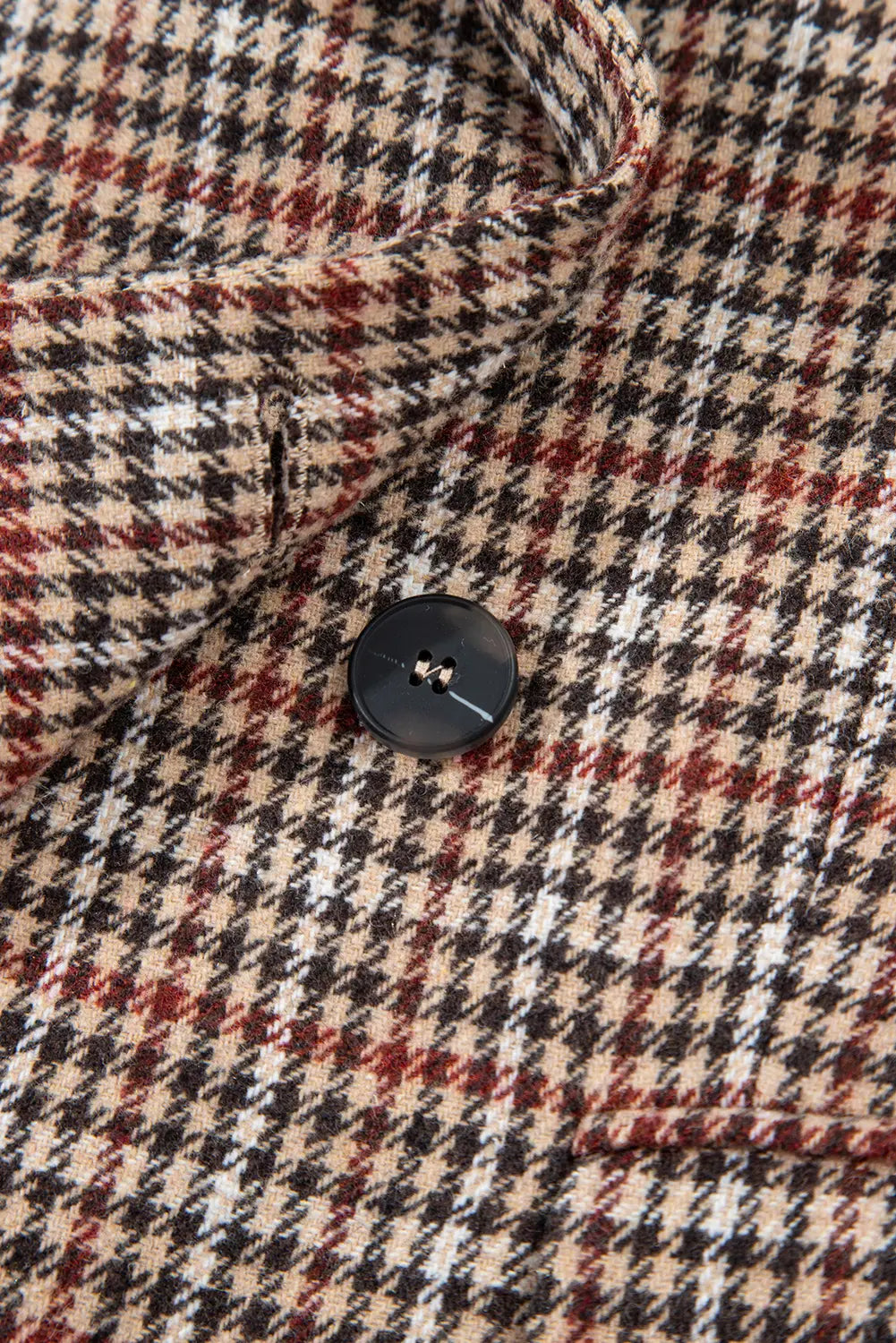 Close-up of a houndstooth patterned fabric with a button.