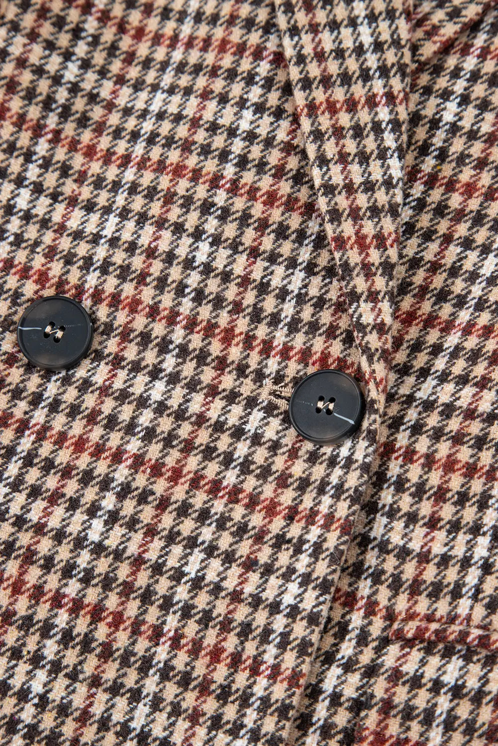 Close-up of a houndstooth patterned fabric with buttons.