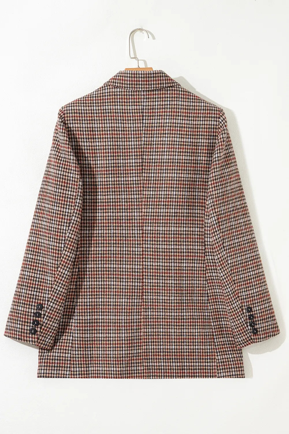Plaid jacket on a hanger against a white background