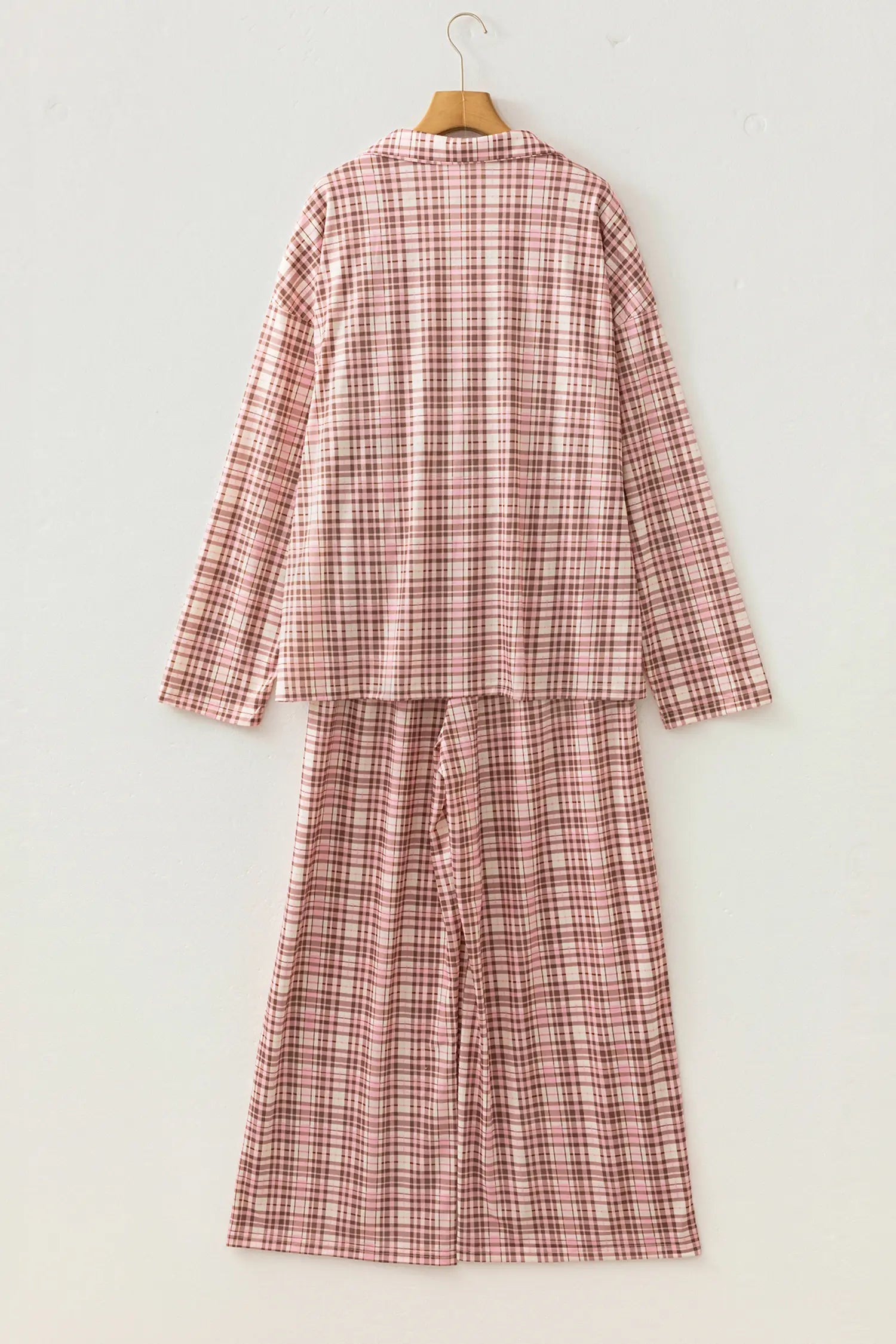Dusty pink and brown plaid pajama set on a wooden hanger.