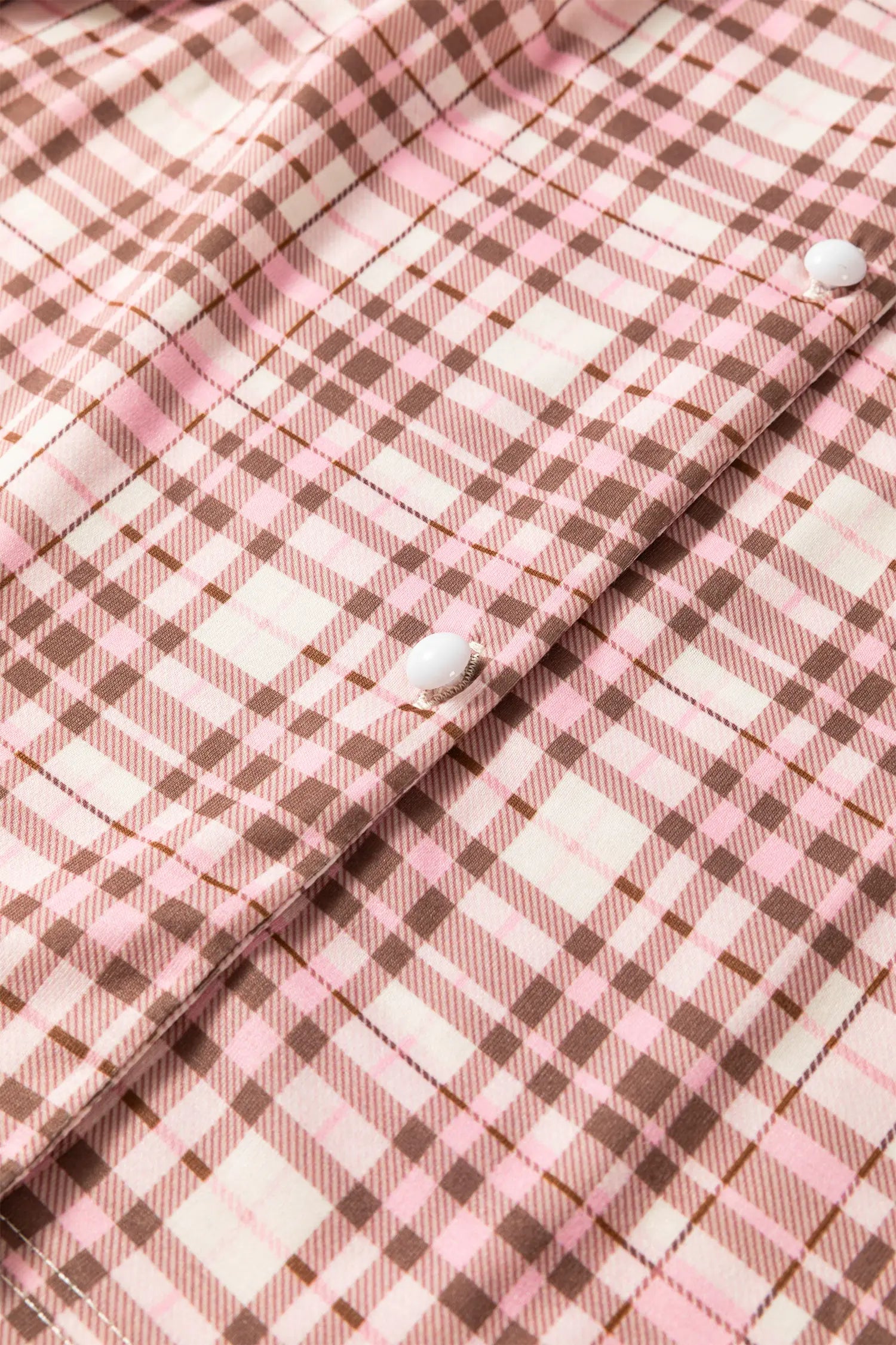 Pink, brown, and white plaid button-up shirt fabric.