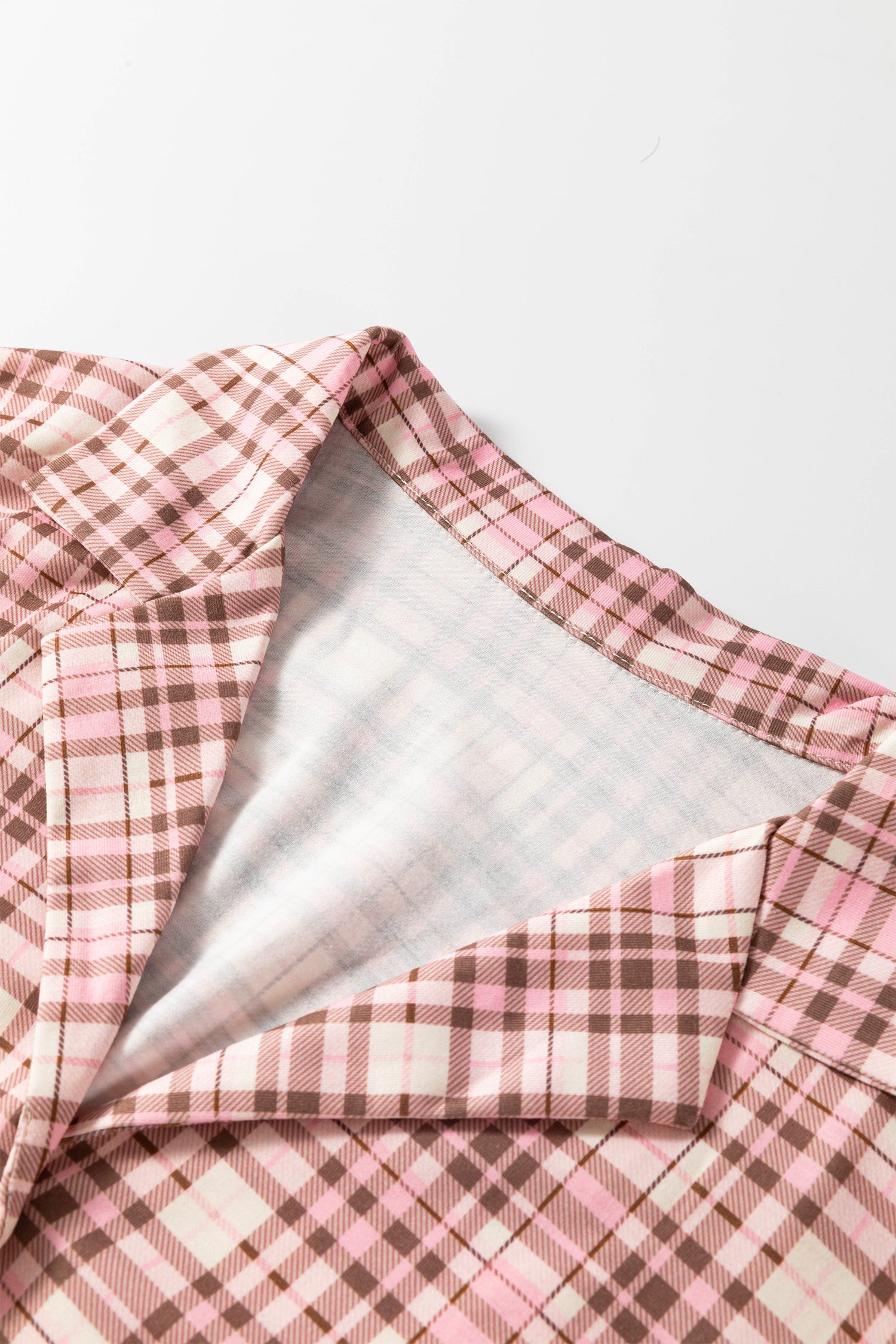 Pink, white, and brown plaid garment with gray lining.