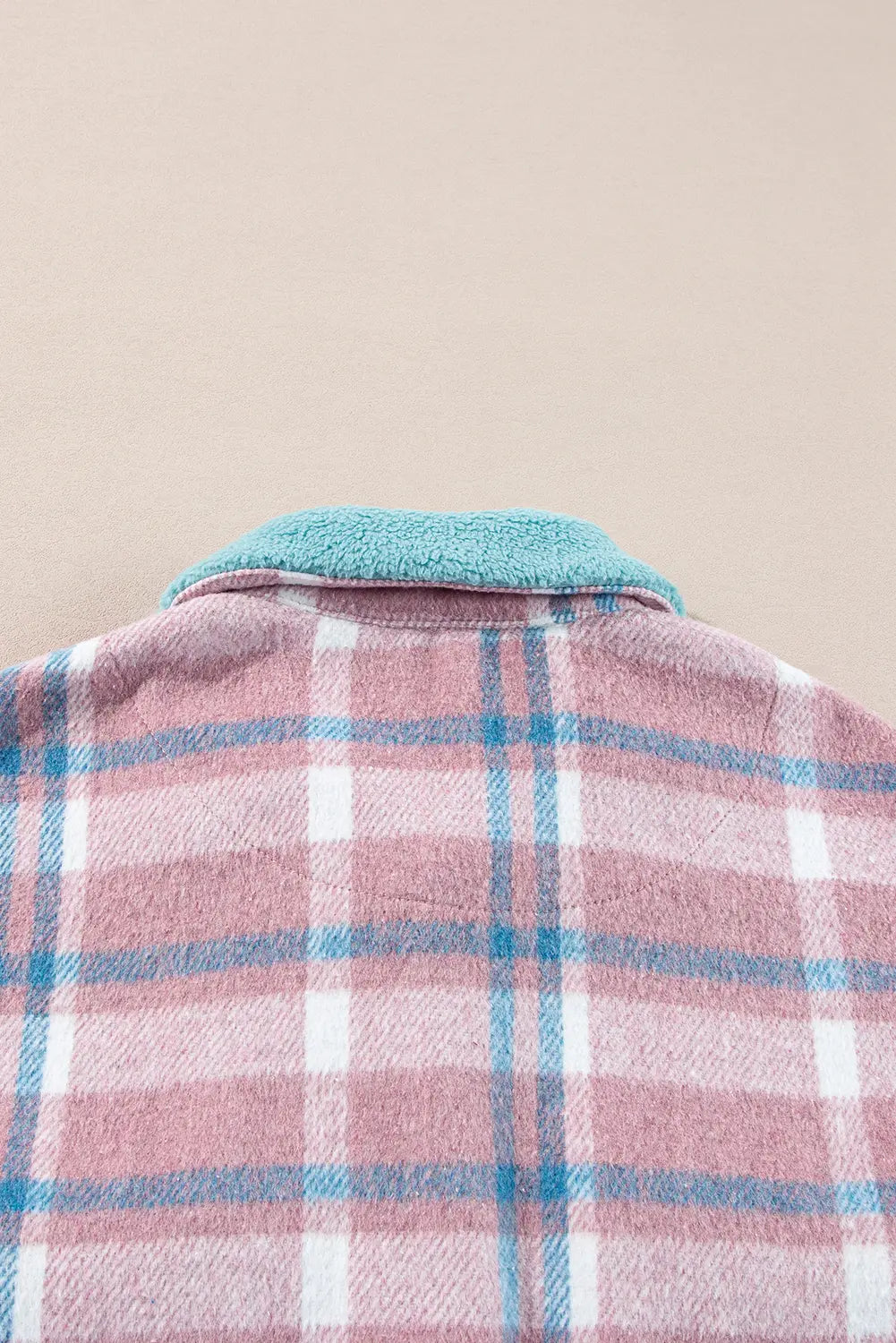 Plaid shirt with a blue collar on a beige background