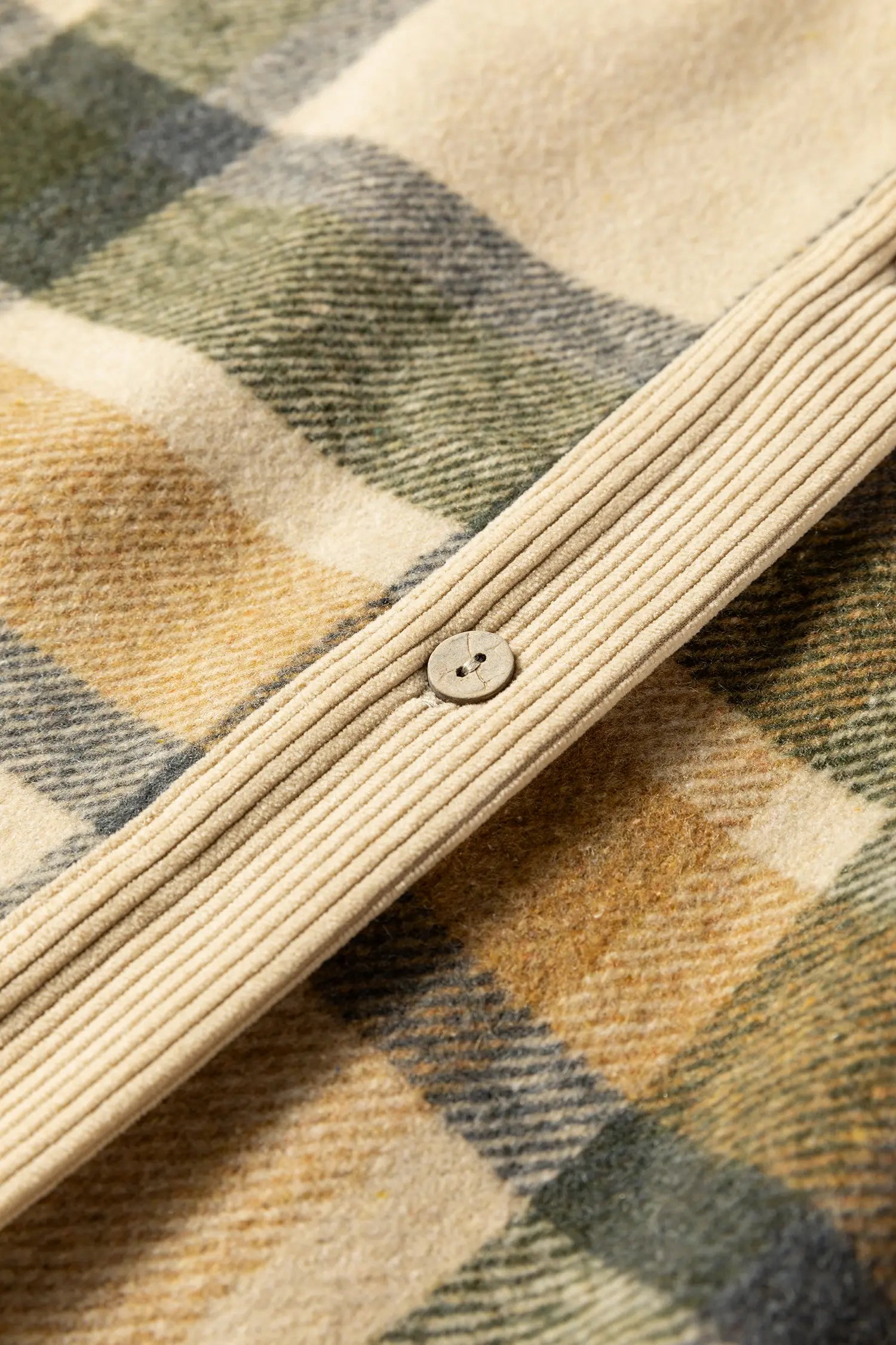 Close-up of a plaid fabric with a button on a checkered pattern