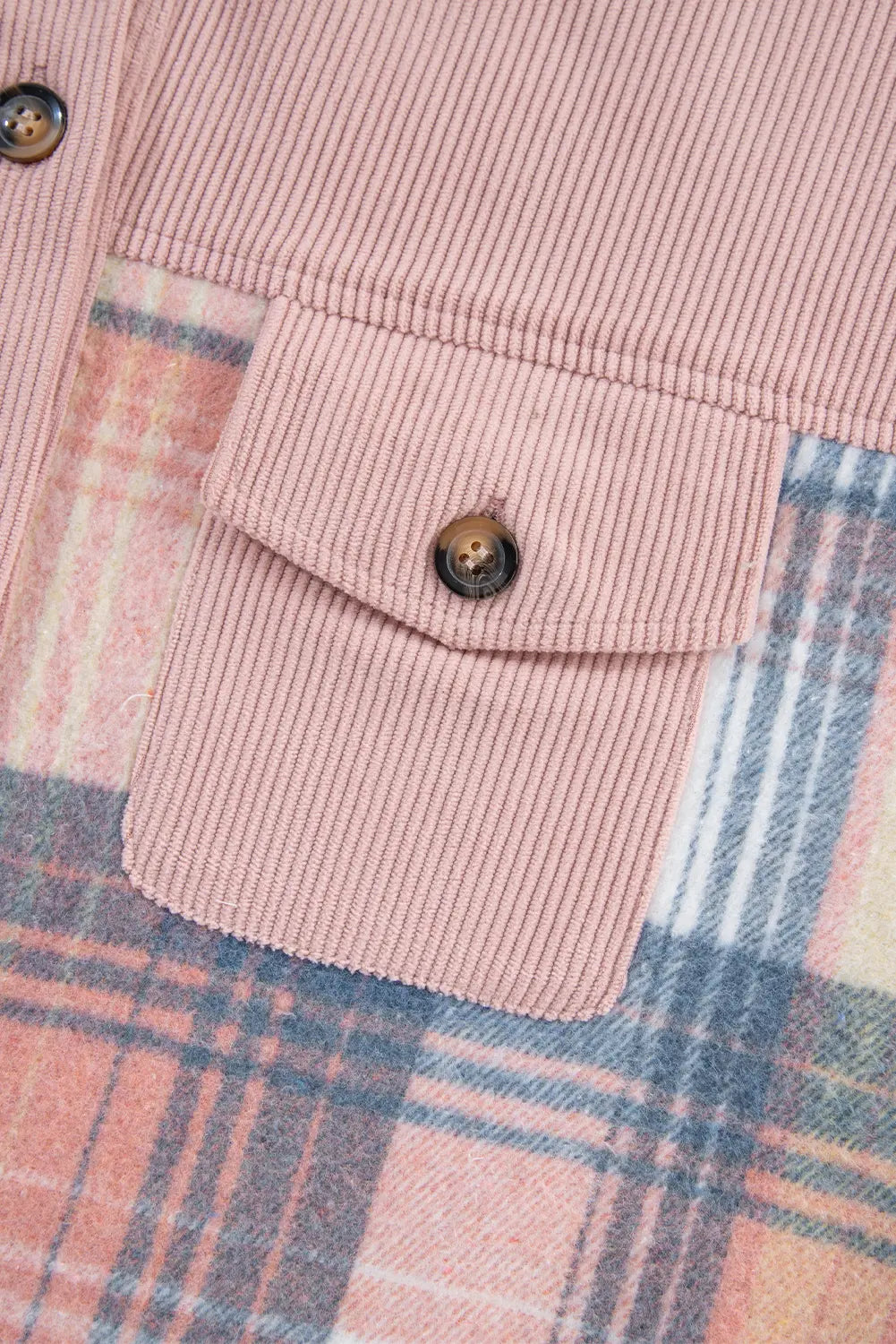 Close-up of a pink corduroy pocket on a plaid fabric background