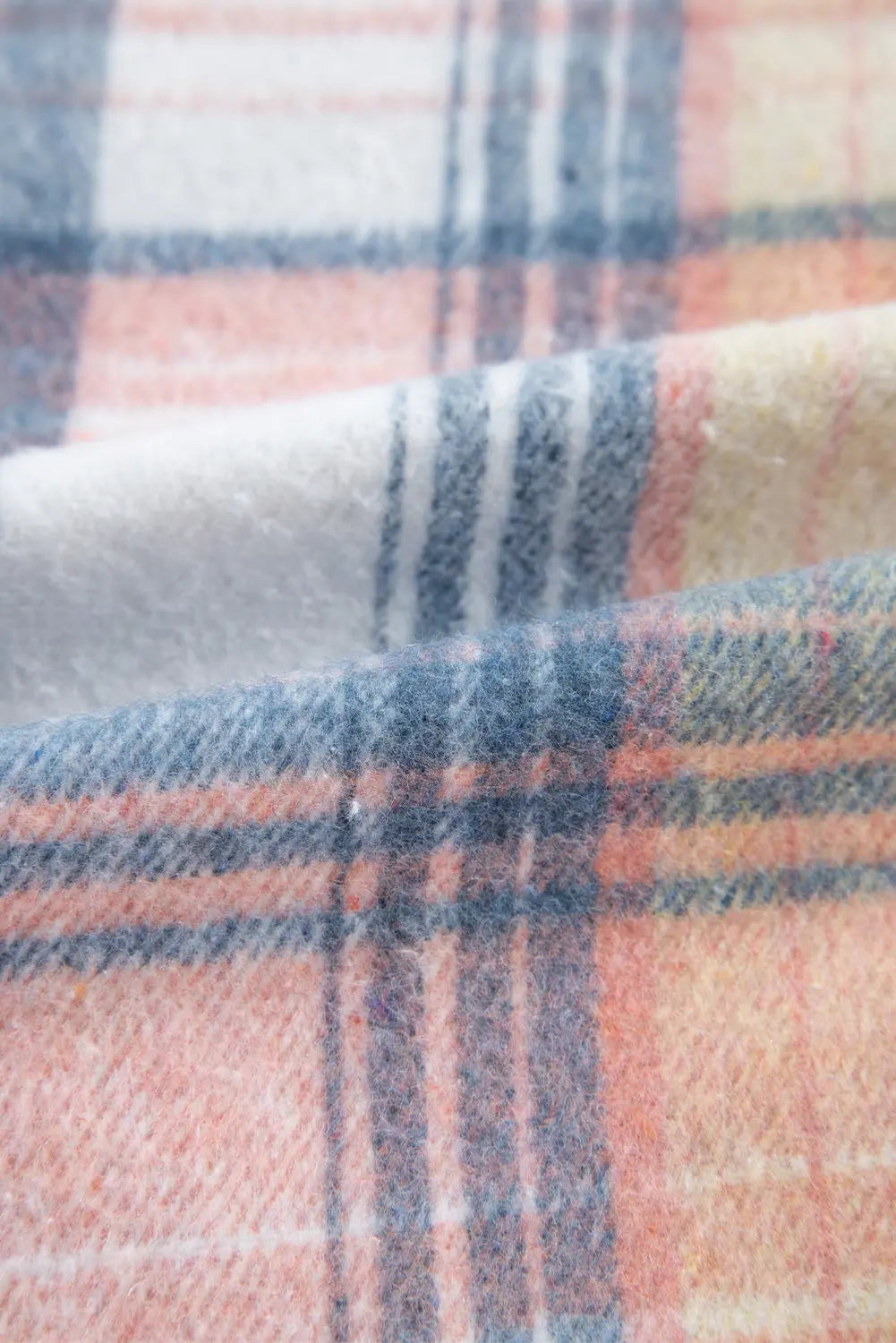 Close-up of plaid fabric with pink, blue, and white colors.