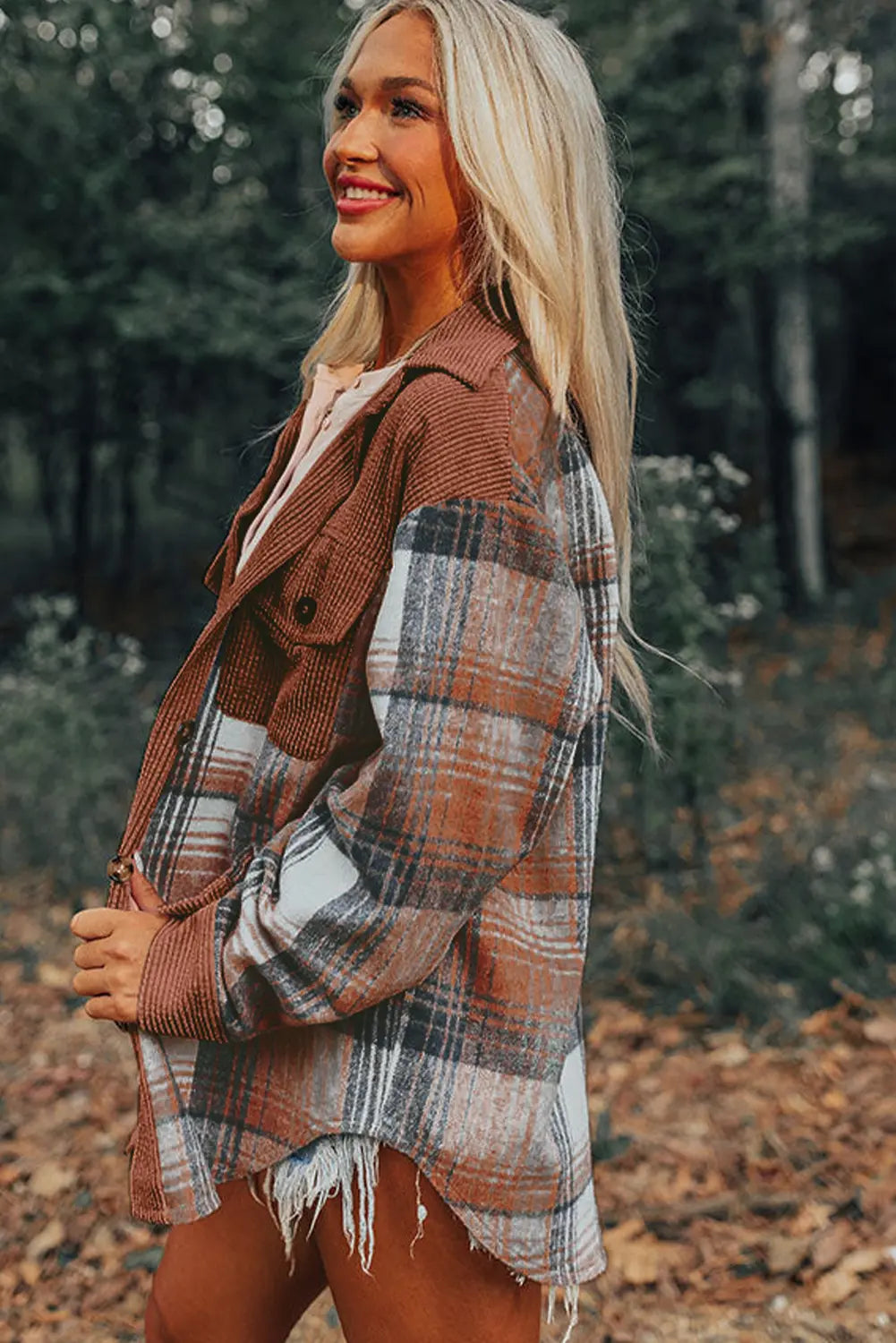 Woman wearing a plaid jacket in a forest setting