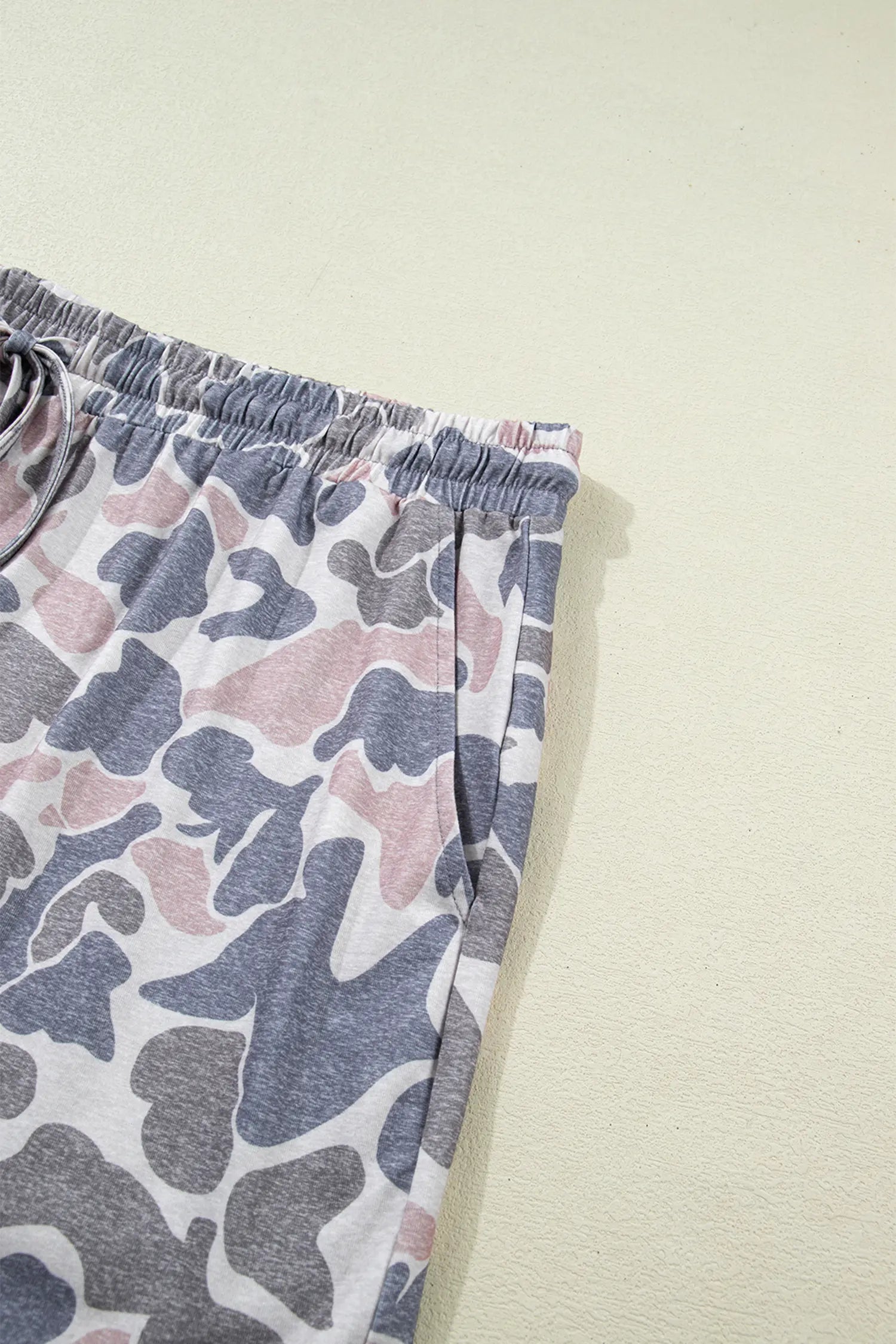 Camouflage-patterned pants on a light beige background