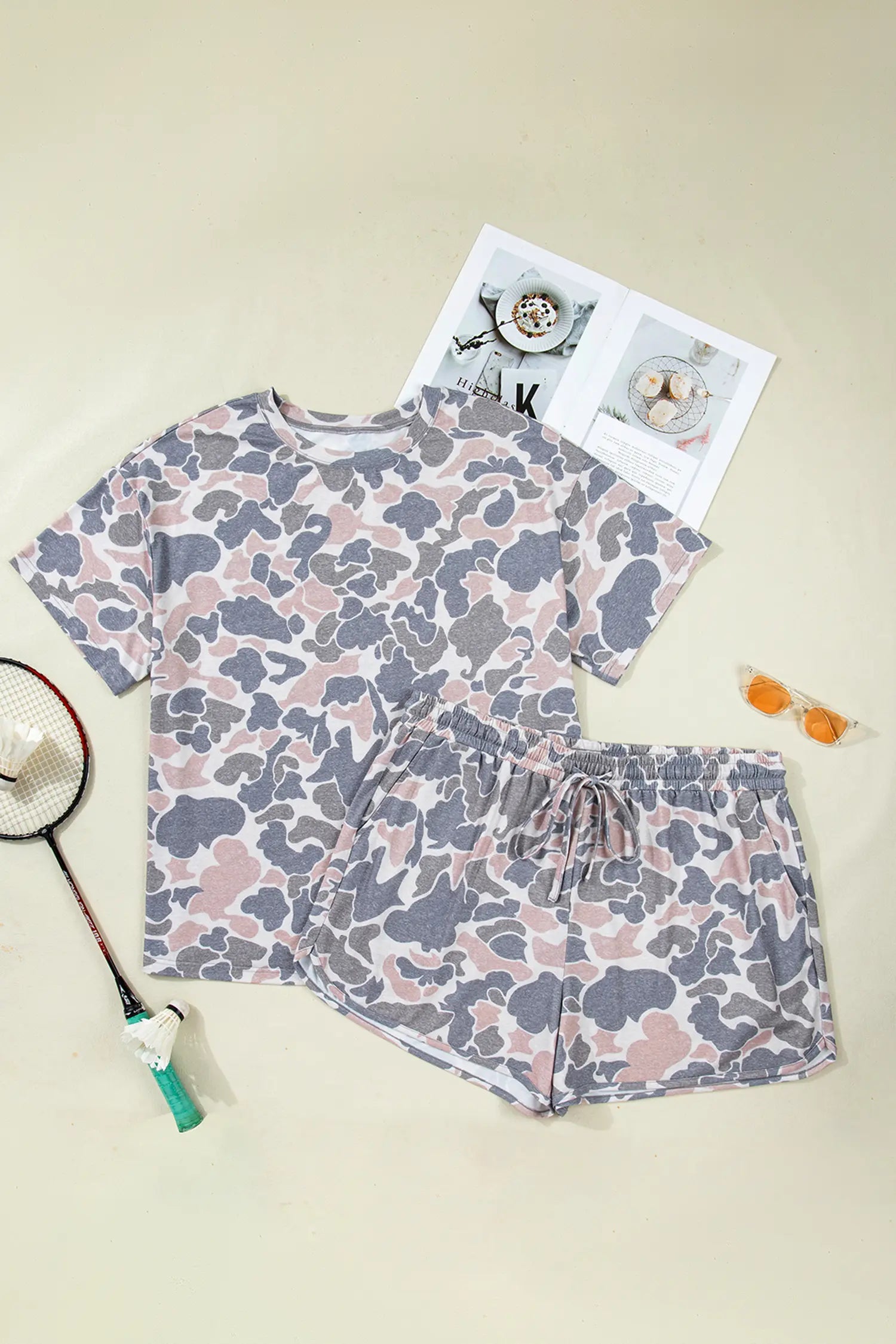 Floral pajama set with a magazine and sunglasses on a beige background