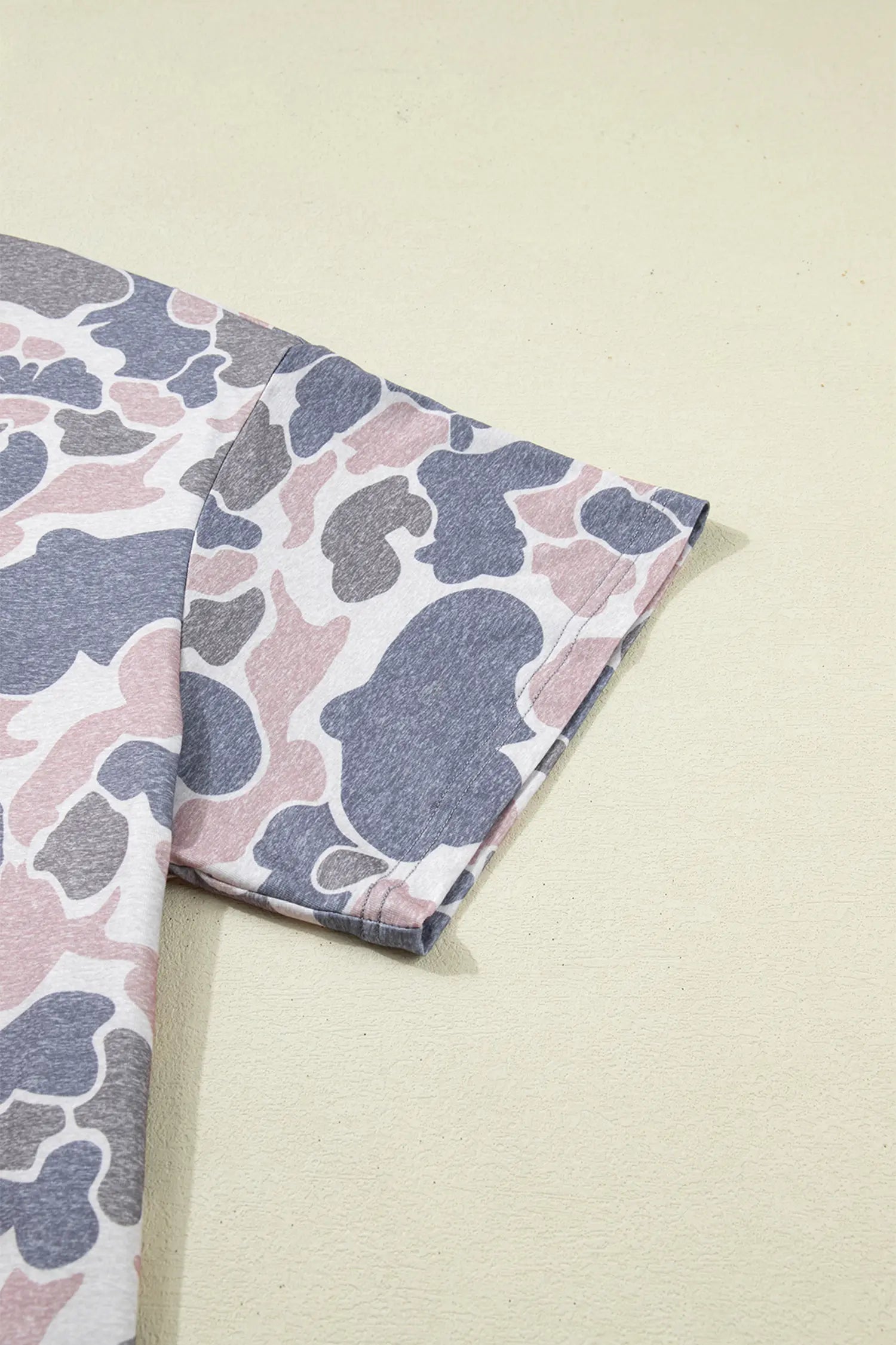 Folded fabric with a camouflage pattern on a light beige background