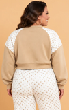Woman shown from behind wearing a beige and white polka dot sweatshirt and matching sweatpants.