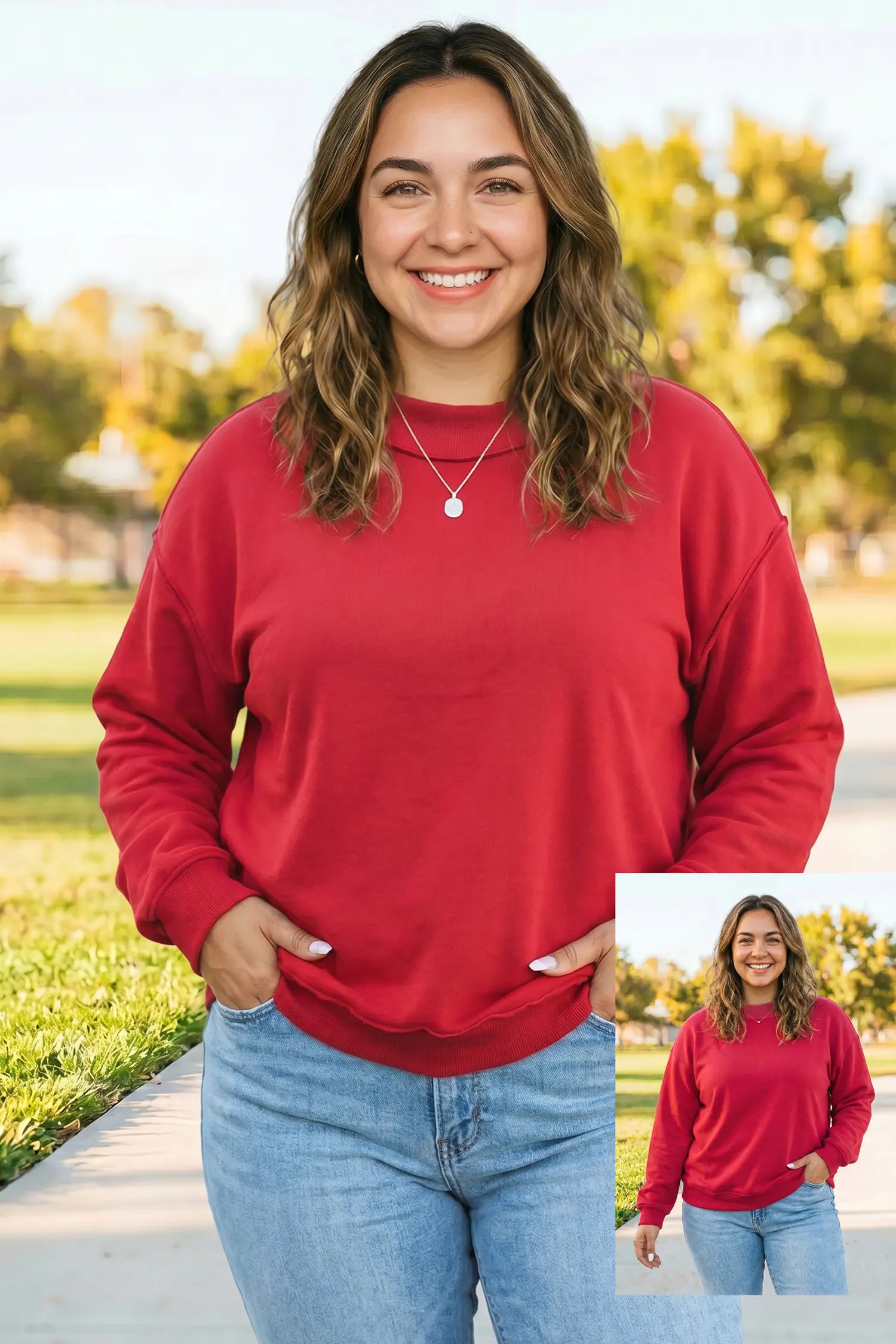 A woman wearing a red crewneck sweatshirt and light blue jeans, standing outdoors on a paved path with trees in the background. A smaller inset image in the bottom right corner shows the same person wearing the sweatshirt.