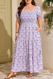 Woman wearing a floral dress standing outdoors against a beige wall.