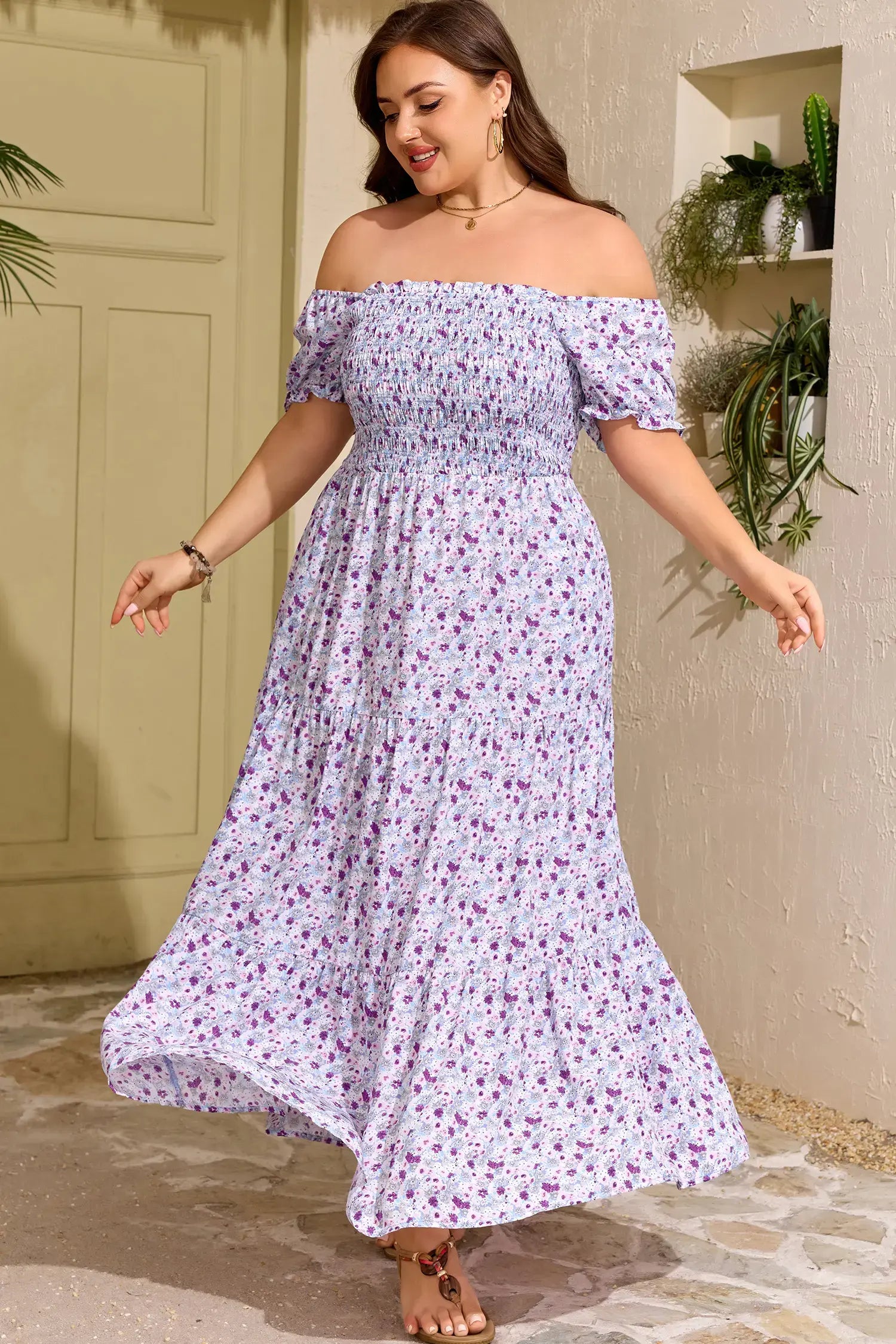 Woman wearing a floral off-shoulder dress standing outdoors.