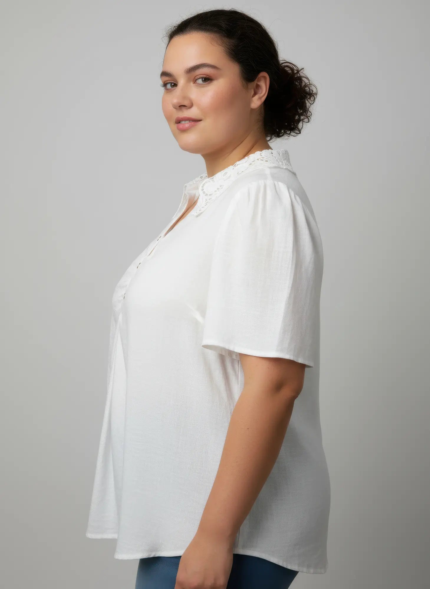 Woman wearing a white blouse against a plain background