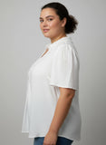 Woman wearing a white blouse against a plain background