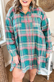A woman wearing a long-sleeve button-up plaid shirt dress in teal green, pink, and white, standing in a home interior setting.
