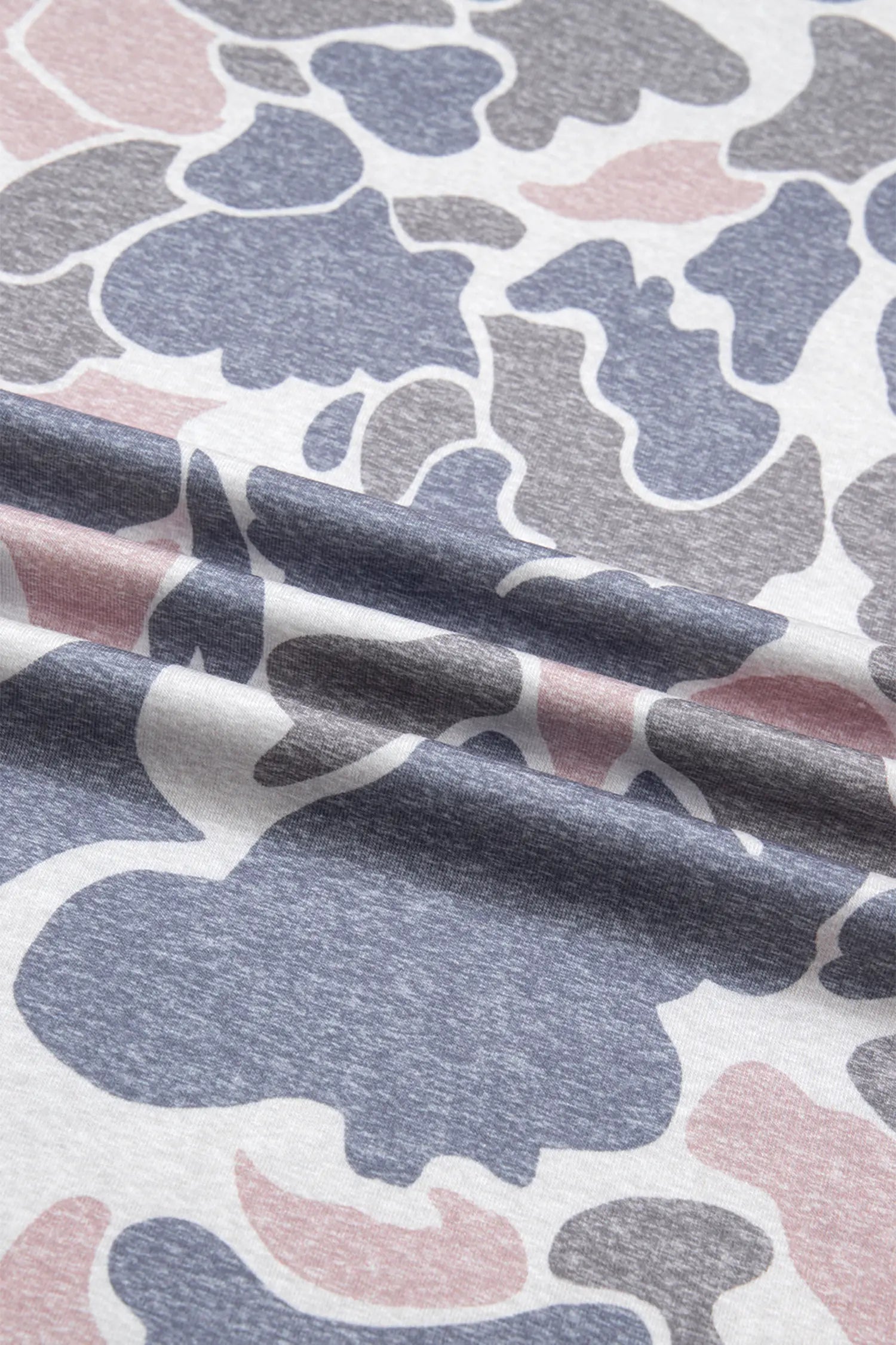 Close-up of fabric with abstract pattern in blue, gray, and pink.