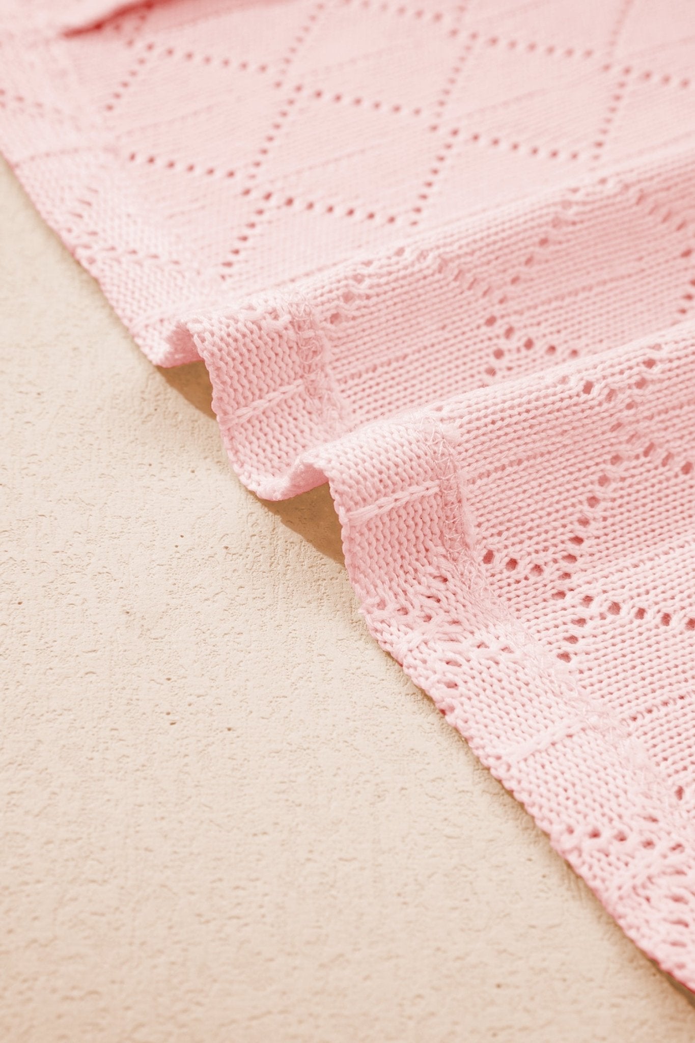 Close-up of pink textured fabric on a beige surface