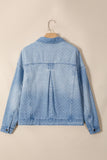 Light blue denim jacket with white polka dots, back view, hanging on a wooden hanger.