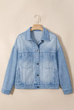 Light blue denim jacket with white micro-dots on a wooden hanger against beige background.