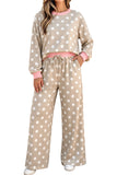 A woman modeling a beige two-piece lounge set with white polka dots, featuring a long-sleeve sweatshirt and matching wide-leg pants, with pink trim and a pink drawstring waist.