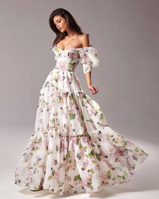 Woman wearing a floral off-shoulder dress against a gray background
