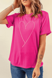 Person wearing a bright pink t-shirt with a heart design on a beige background