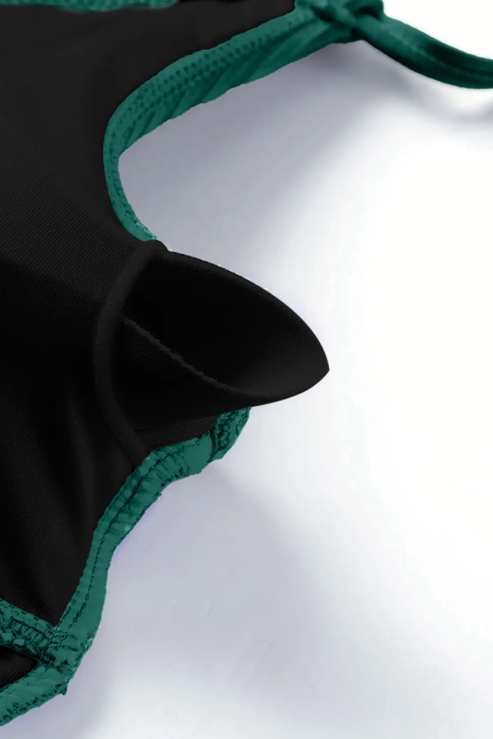 Black and green bikini top on a white background
