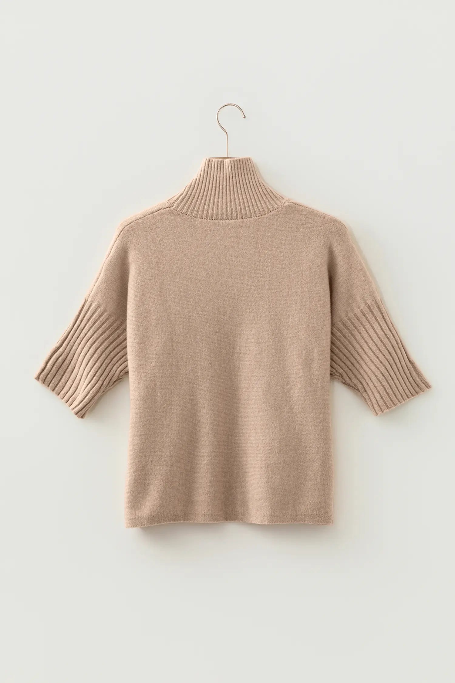 Light beige knit turtleneck sweater with ribbed elbow-length sleeves on a wire hanger against off-white background.