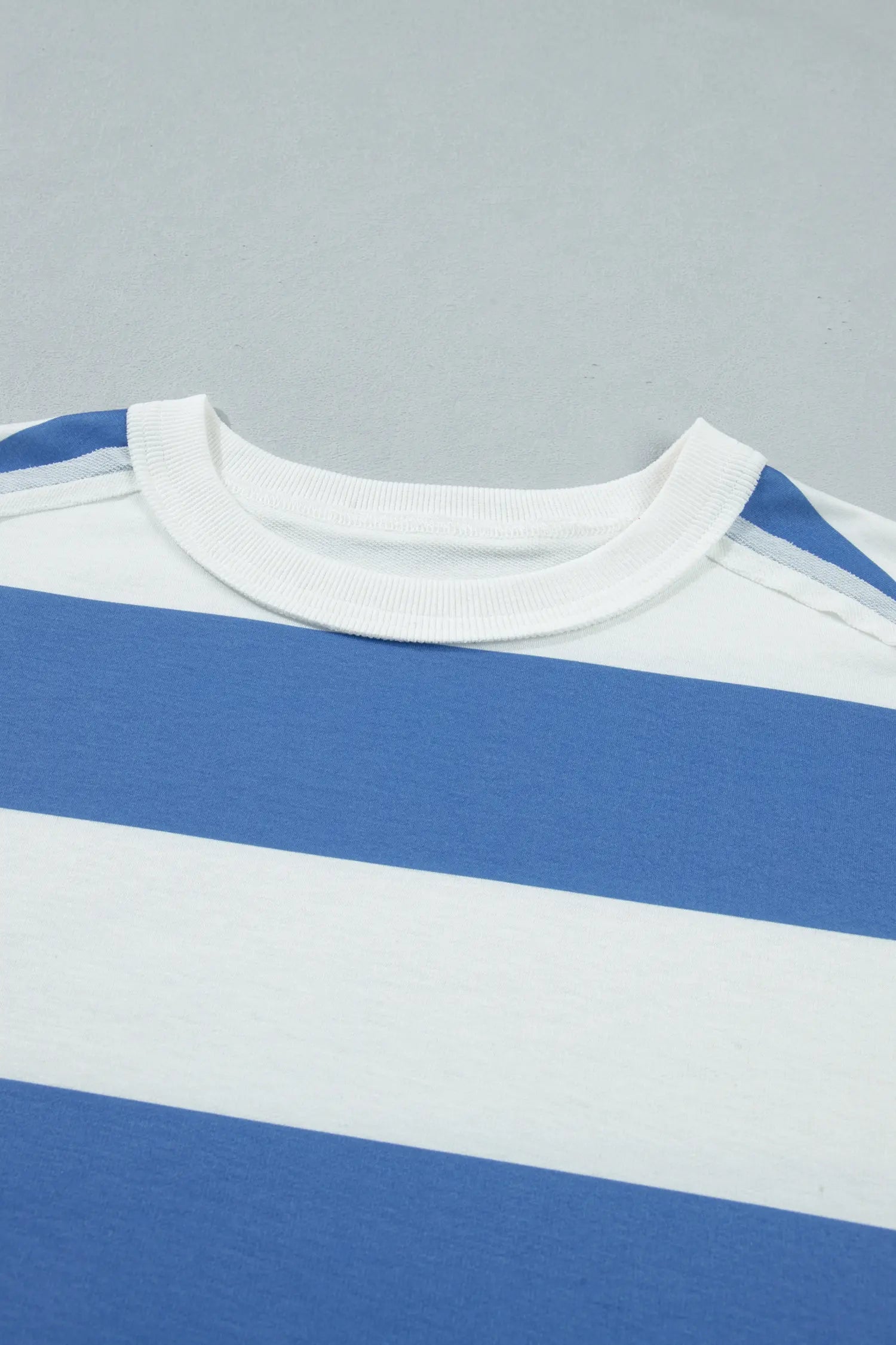Close-up of a blue and white striped shirt on a gray background