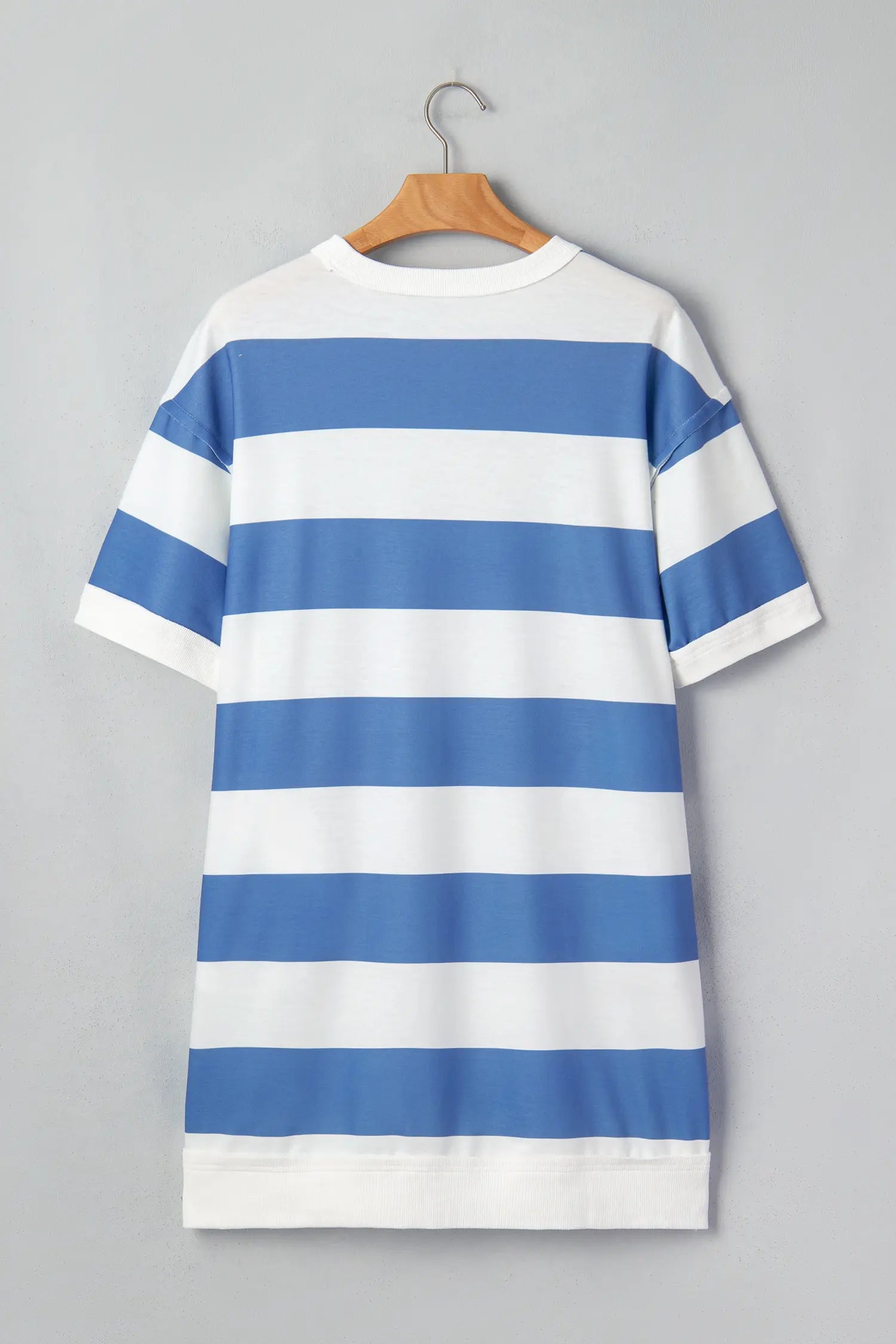 Blue and white striped dress on a hanger against a gray background