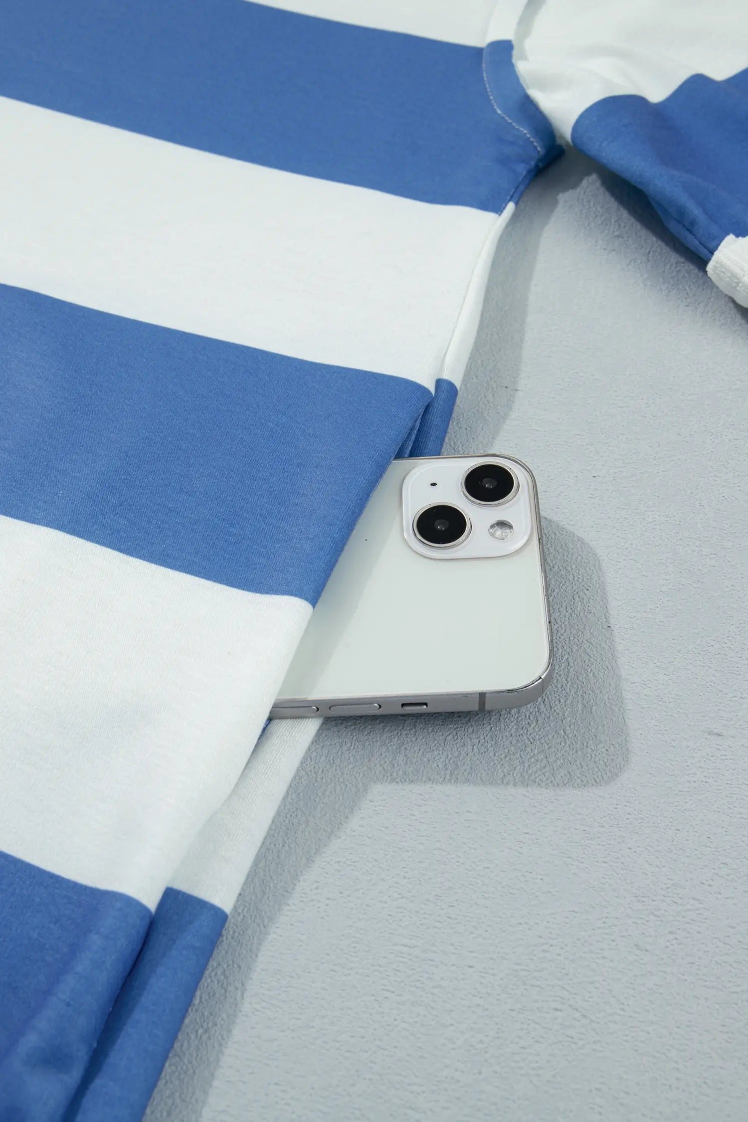 Phone lying on a blue and white striped fabric