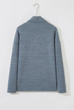 A textured blue-gray ribbed knit sweater with a mock neck, shown from the back on a white hanger against a white wall.