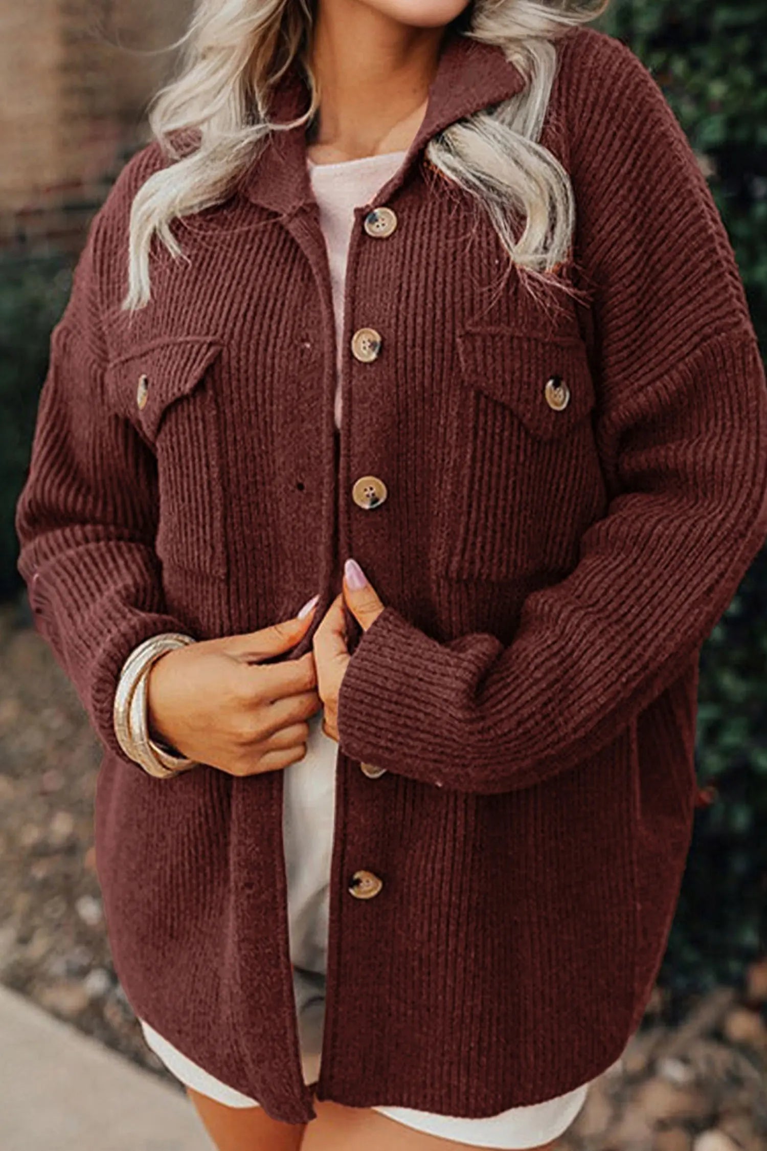 Person wearing a brown corduroy jacket with a blurred background