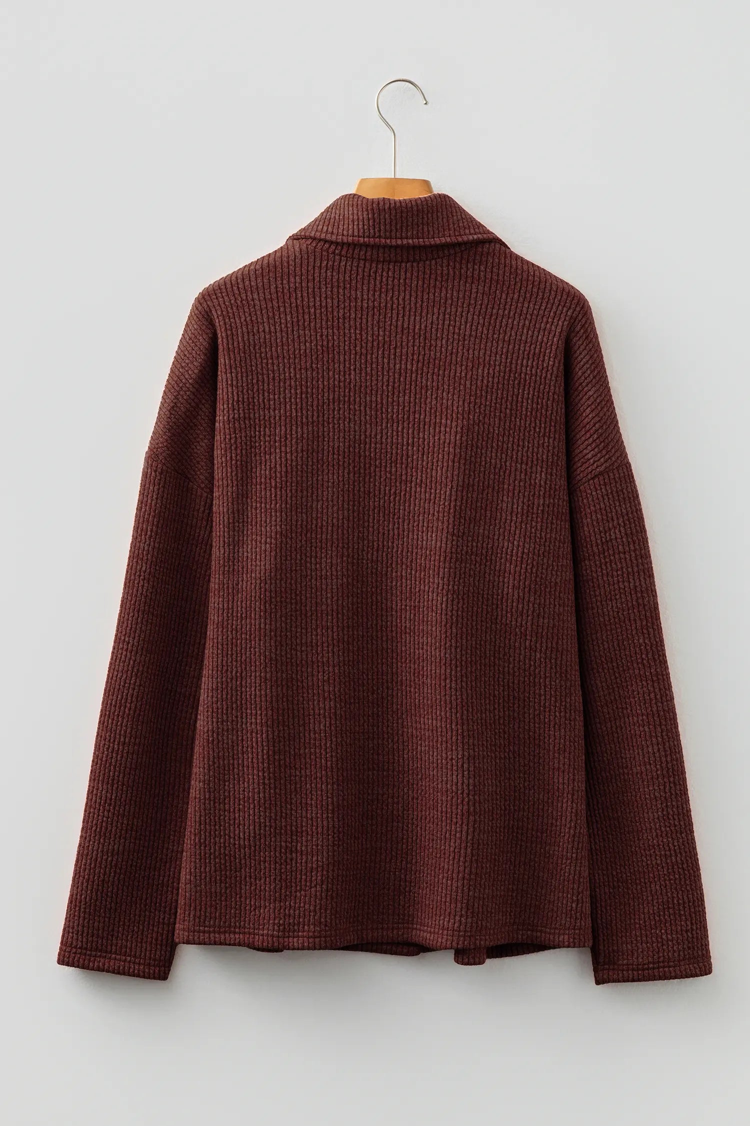 Brown textured shirt on a hanger against a white background