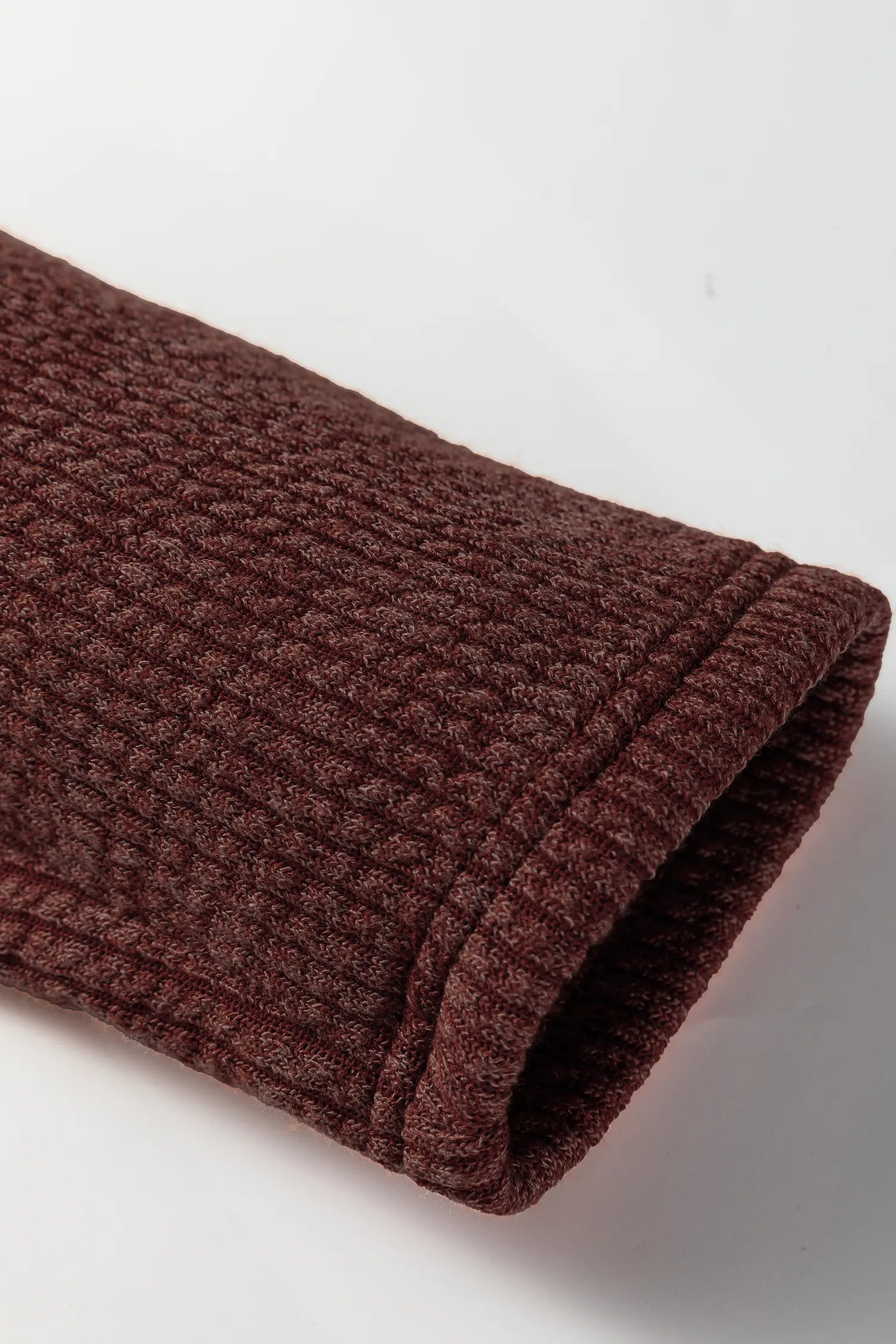 Brown textured towel rolled up on a white background