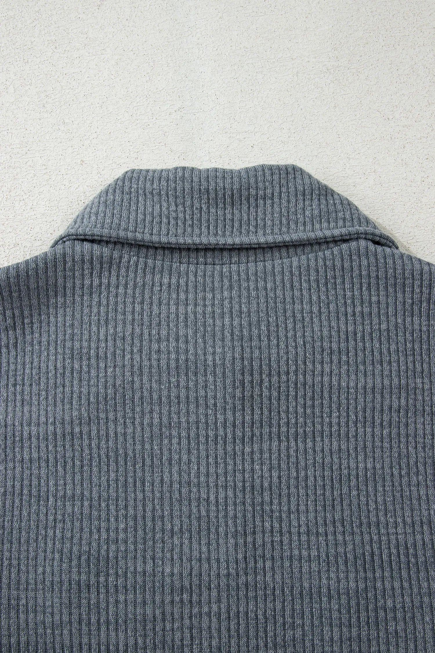 Close-up of a textured gray garment on a light gray background