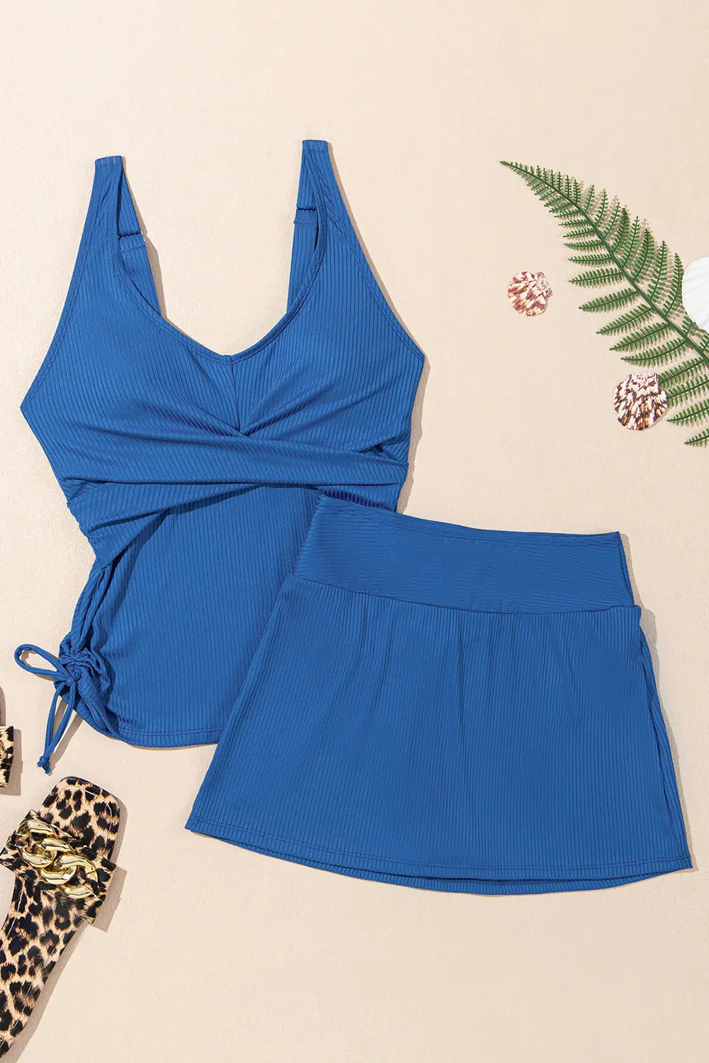 Blue swimsuit set on a beige background with decorative elements