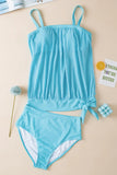 Blue swimsuit set on a beige surface with decorative items.